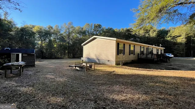 a view of a house with backyard and sitting area