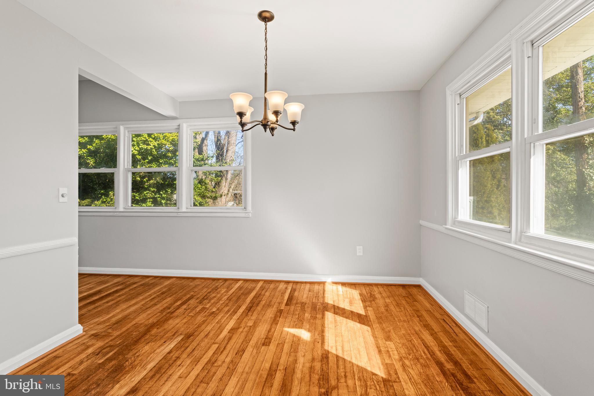1407 Shefford Road Baltimore, MD 21239 - Photo 10 of 35 a view of an empty room with wooden floor and a window