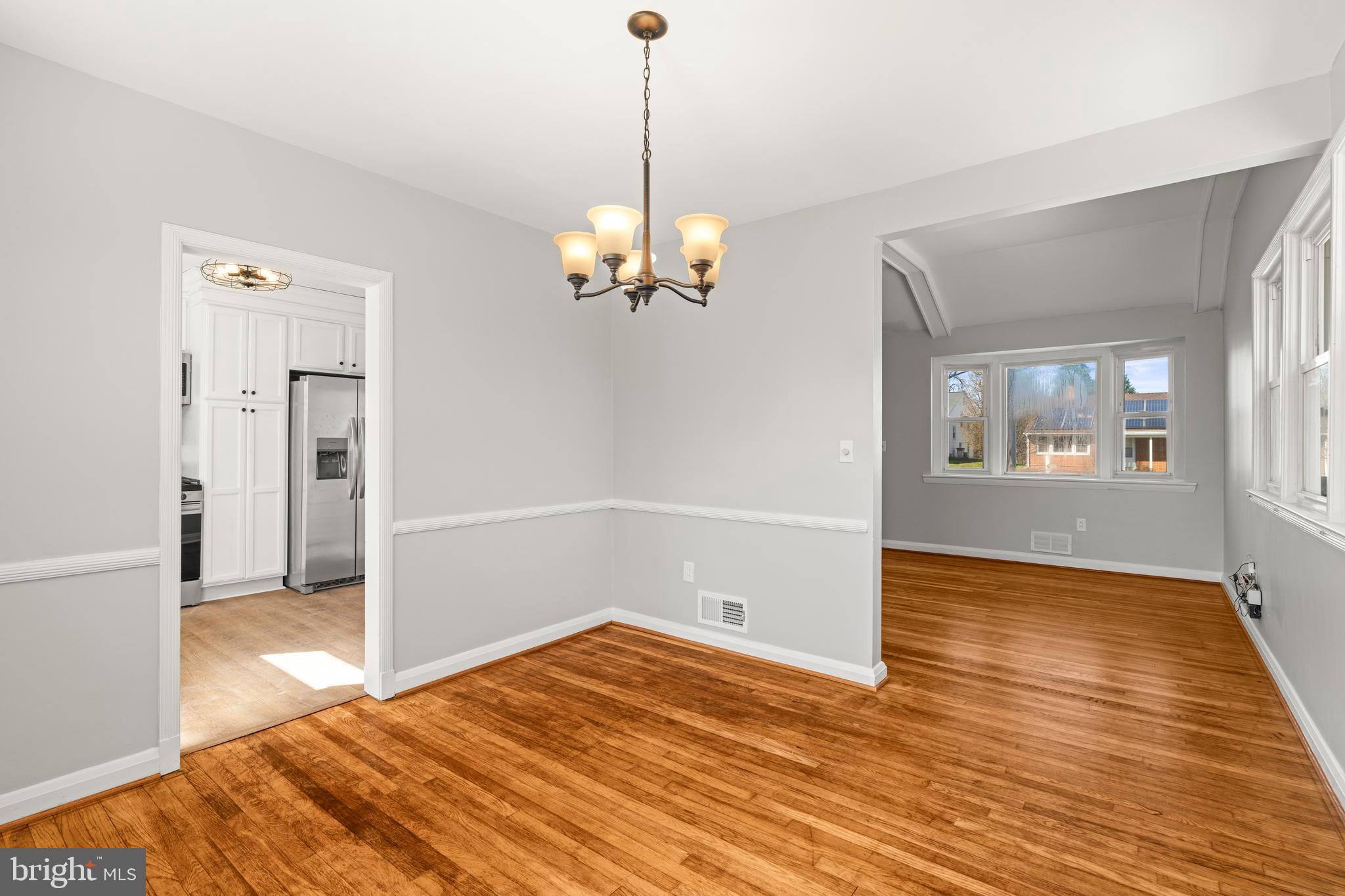 1407 Shefford Road Baltimore, MD 21239 - Photo 35 of 35 a view of a room with wooden floor staircase and a chandelier