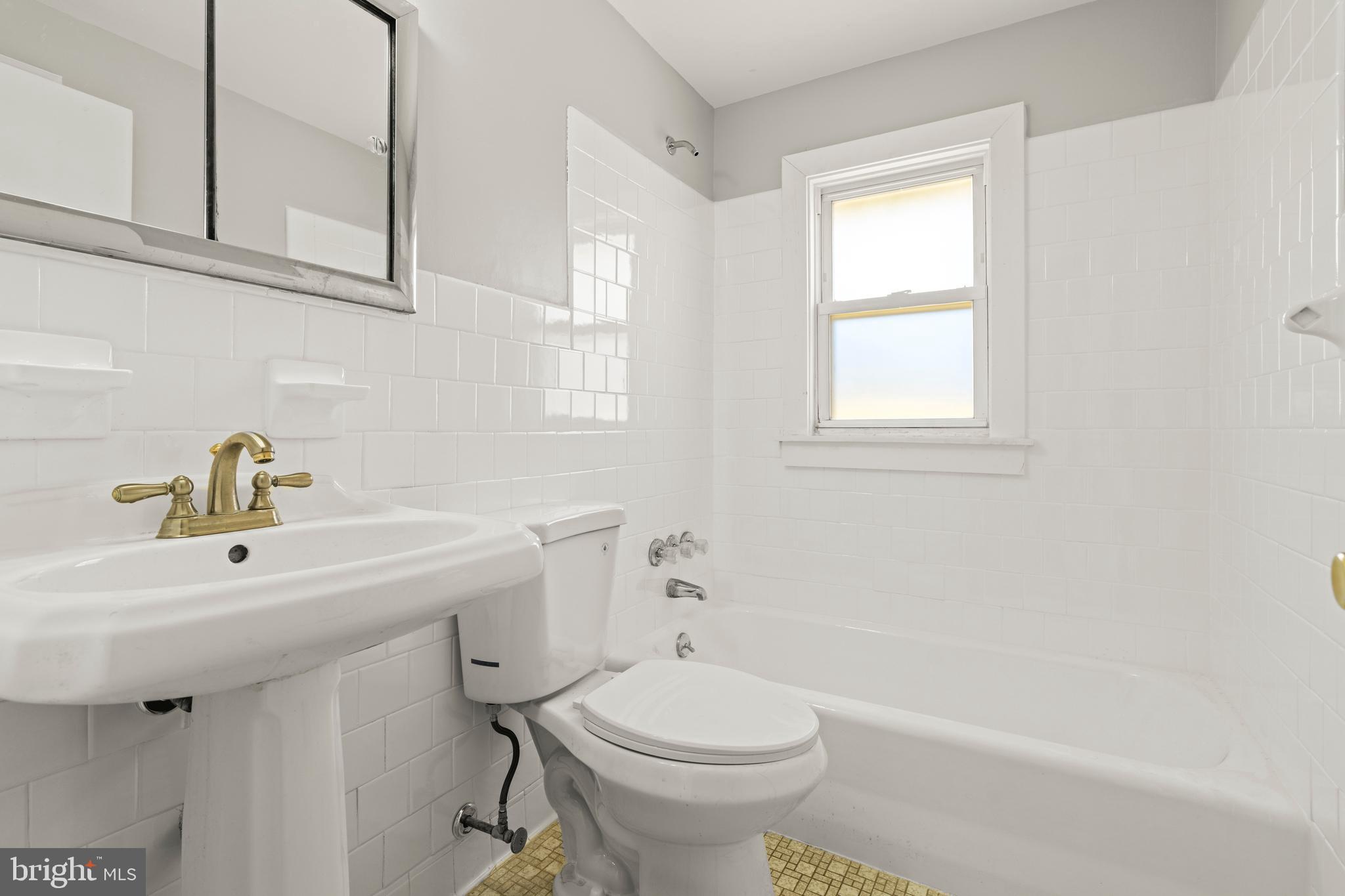 1407 Shefford Road Baltimore, MD 21239 - Photo 22 of 35 a bathroom with a sink a toilet and a window