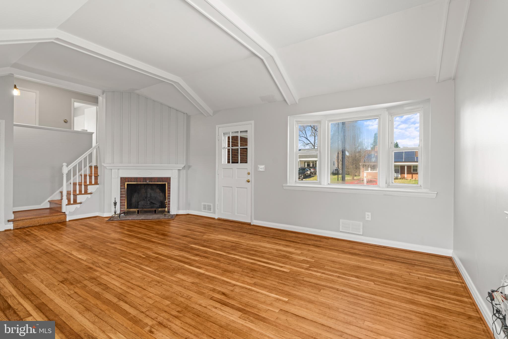 1407 Shefford Road Baltimore, MD 21239 - Photo 6 of 35 a view of empty room with wooden floor and fireplace
