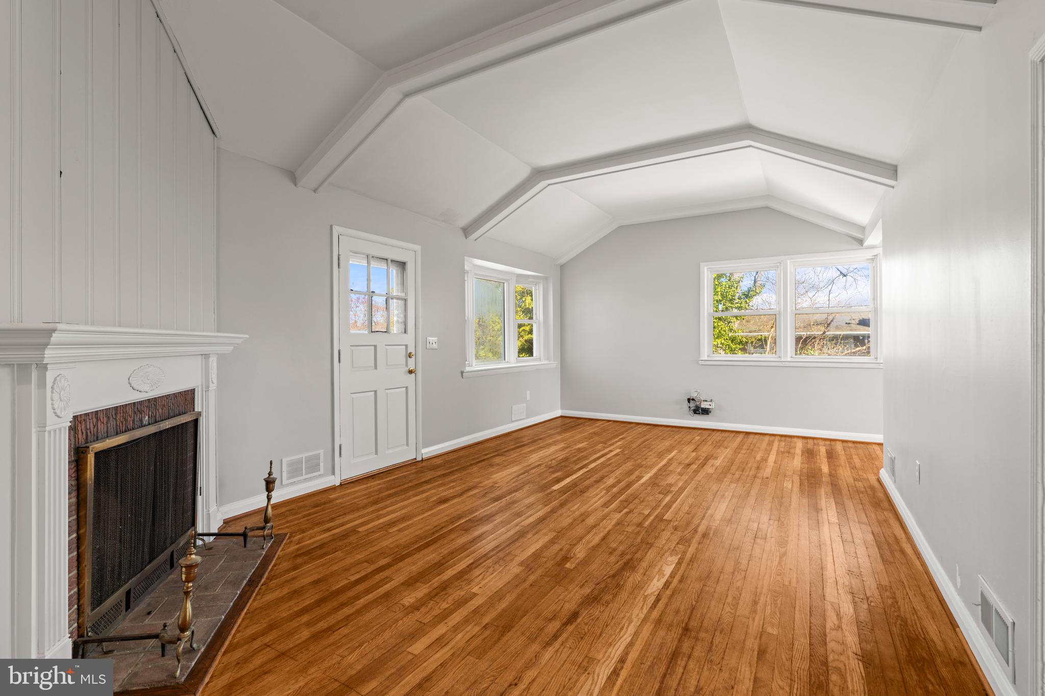 1407 Shefford Road Baltimore, MD 21239 - Photo 7 of 35 a view of empty room with wooden floor and fireplace