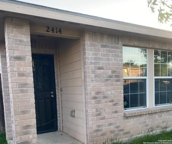 a brick house with a door and balcony