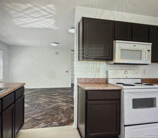 a kitchen with stainless steel appliances granite countertop a stove microwave and sink