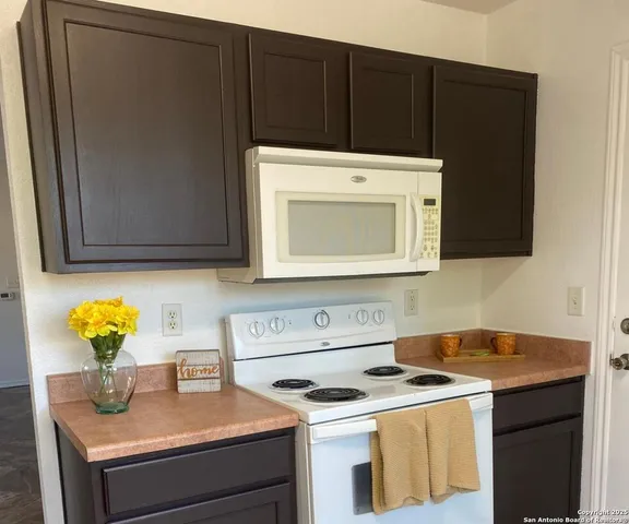 a kitchen with a sink cabinets and a microwave
