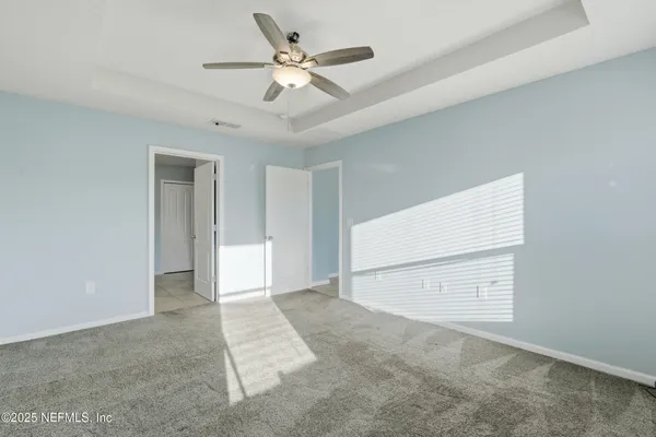 a view of an empty room with a ceiling fan