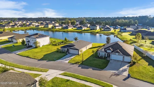 an aerial view of a house with a swimming pool yard and lake view