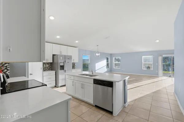 a kitchen with stainless steel appliances granite countertop a sink and a refrigerator
