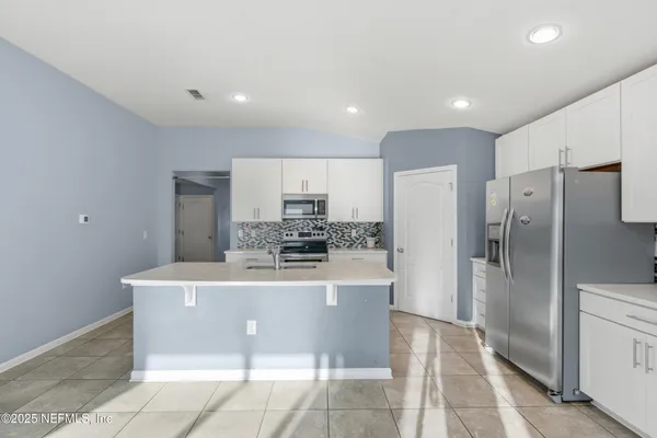 a kitchen with stainless steel appliances a refrigerator sink and stove