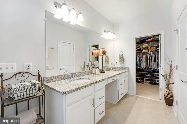 a view of a hallway with wooden floor and a bathroom