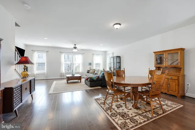 a living room with furniture kitchen view and a wooden floor