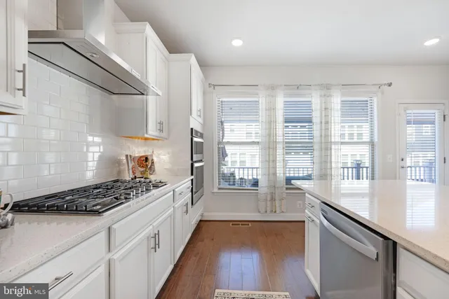 a large white kitchen with lots of counter space dining table and chairs