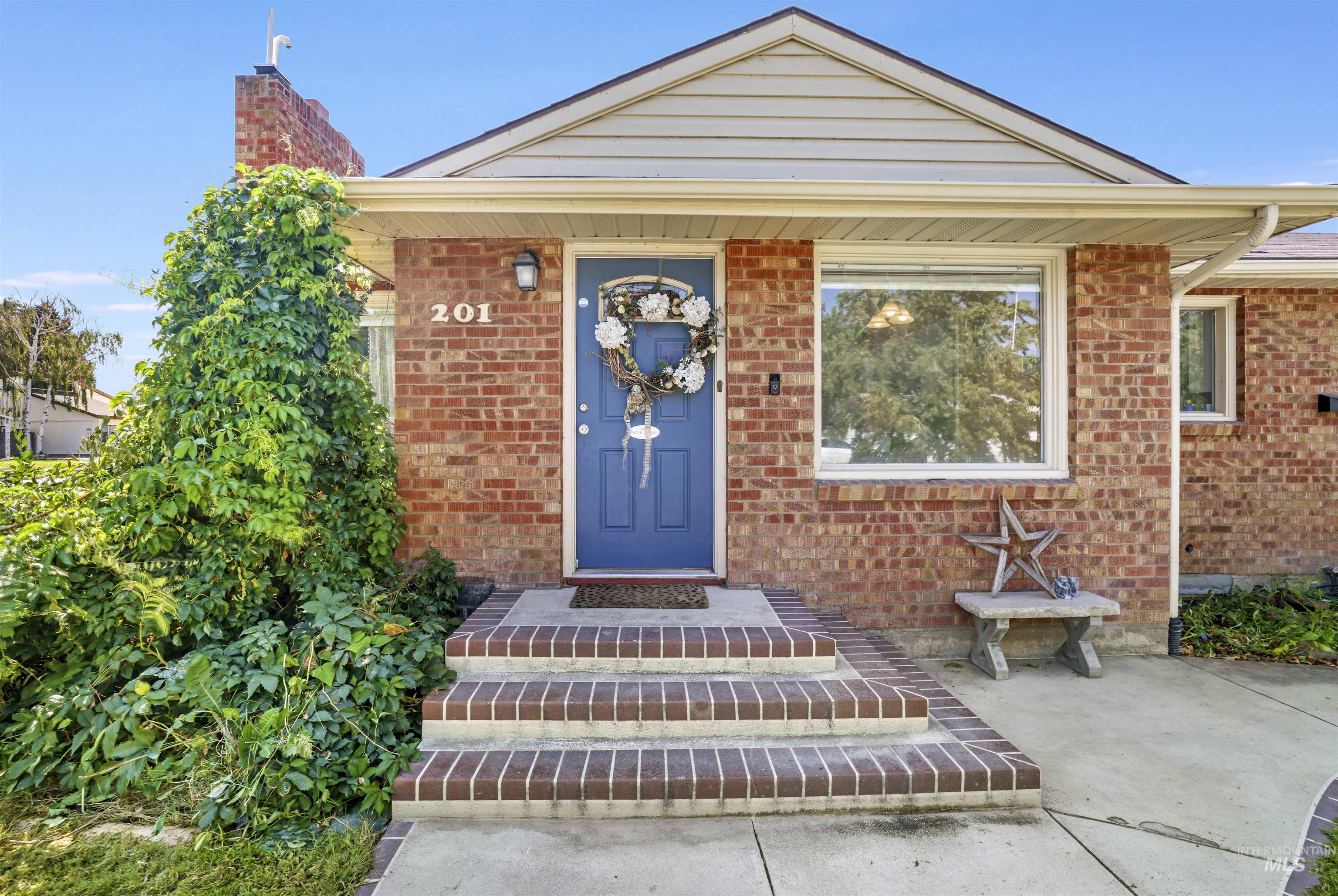 Entrance to property with brick siding and a chimney