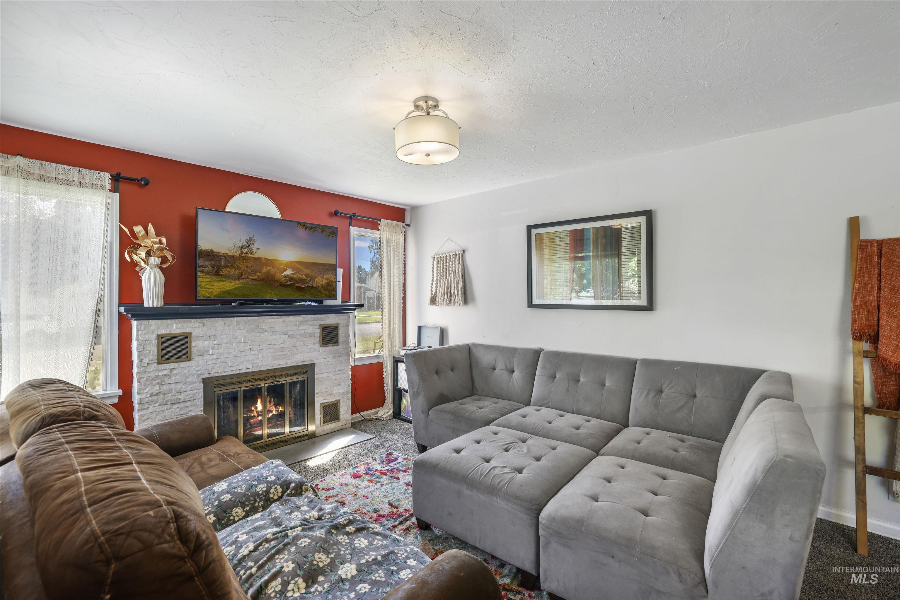 201 West 19th Street Burley, ID 83318 - Photo 5 of 31 Carpeted living area featuring a stone fireplace