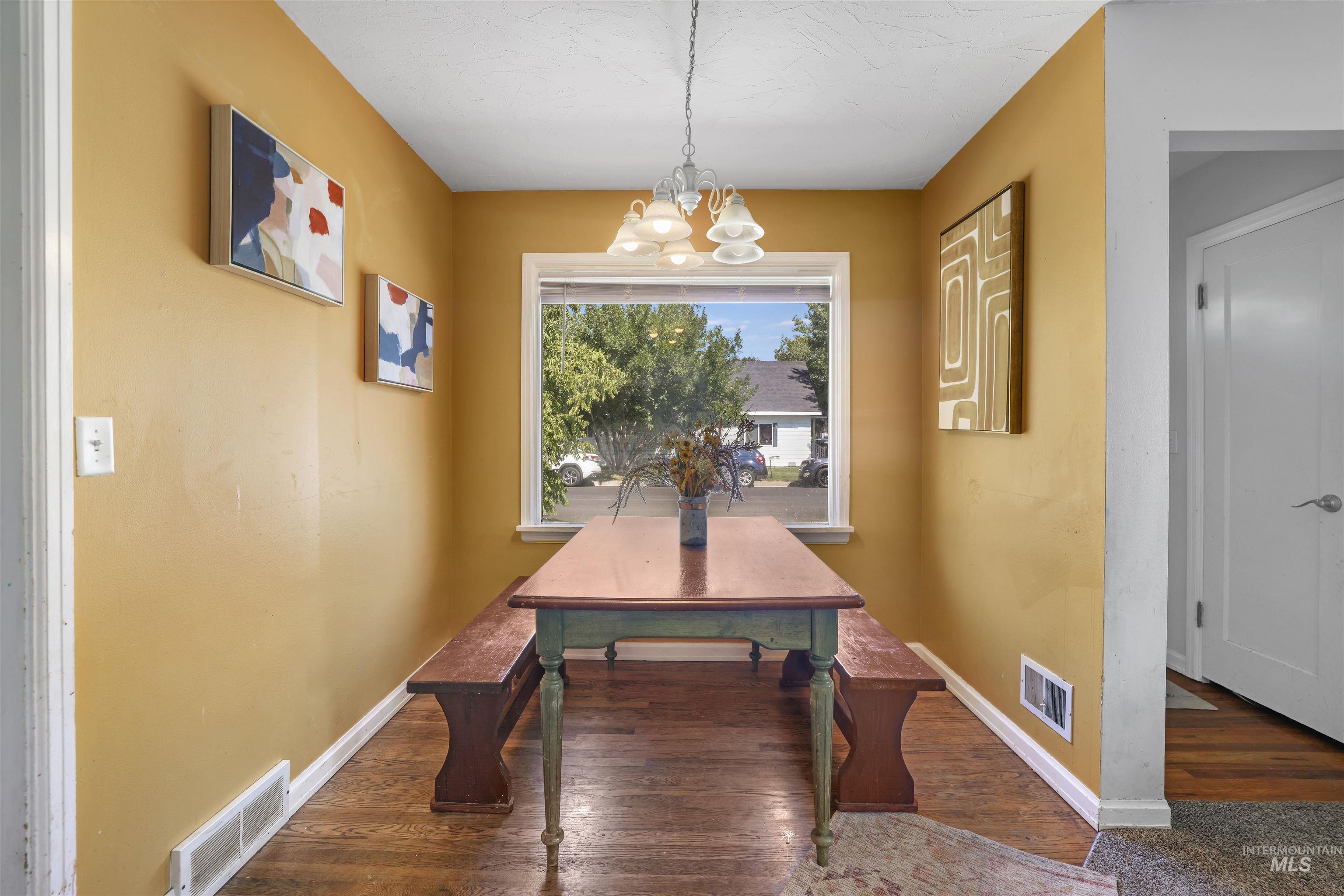 201 West 19th Street Burley, ID 83318 - Photo 6 of 31 Dining space with a chandelier and dark wood-type flooring