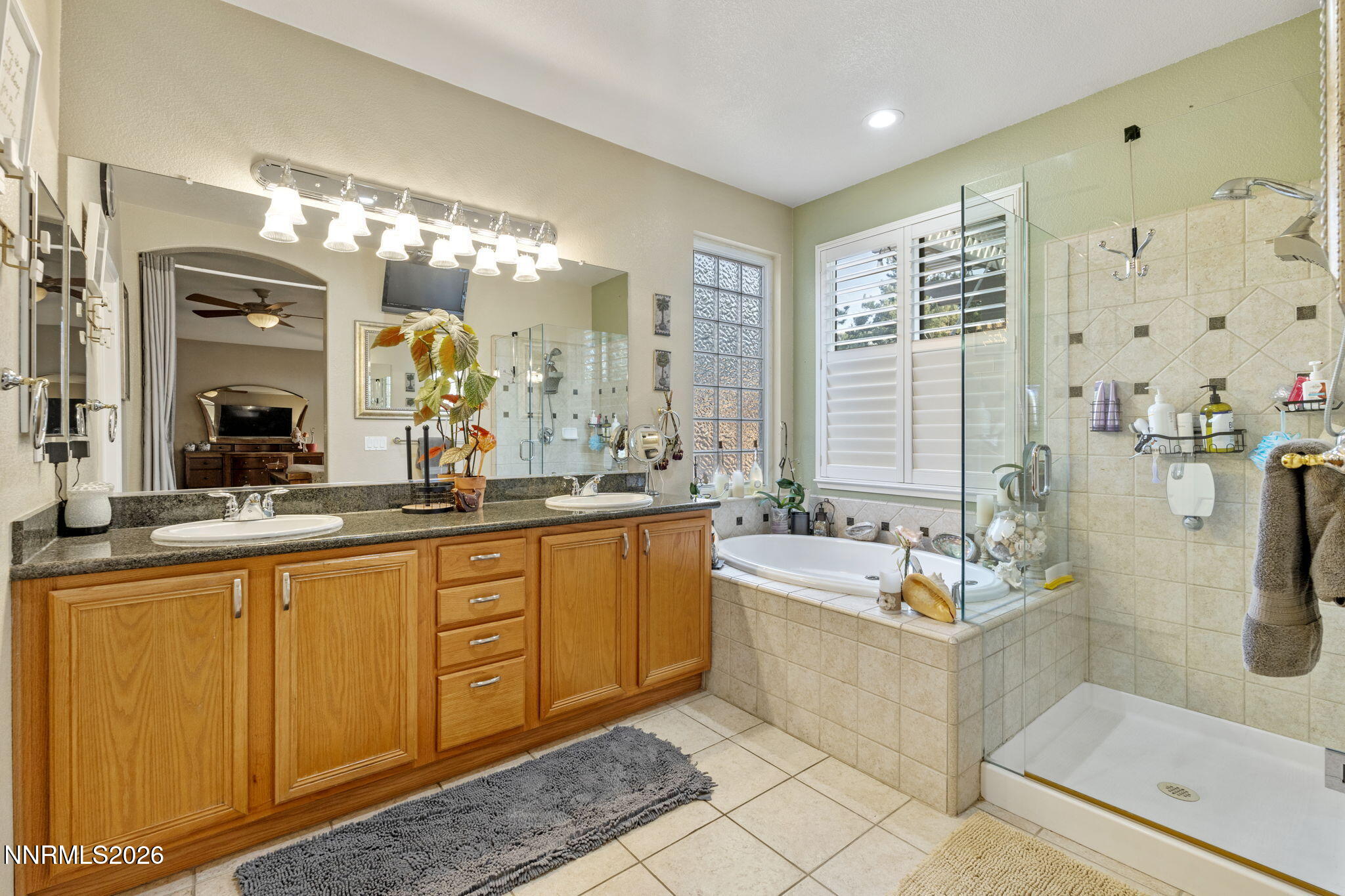 3239 Banestone Road Sparks, NV 89436 - Photo 29 of 38 a spacious bathroom with a double vanity sink a large mirror a bathtub and next to a window