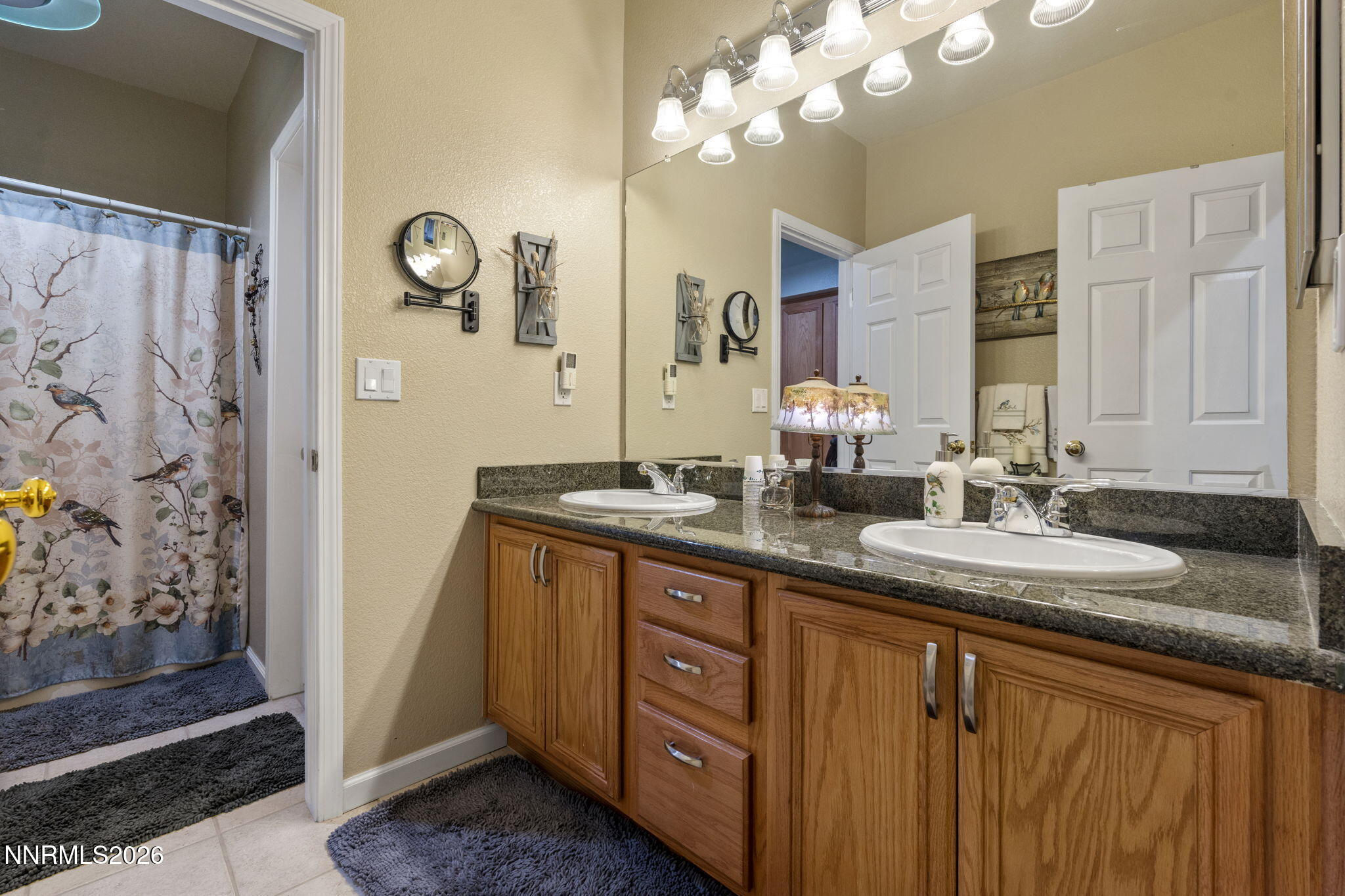 3239 Banestone Road Sparks, NV 89436 - Photo 32 of 38 a bathroom with a granite countertop sink a mirror and a shower