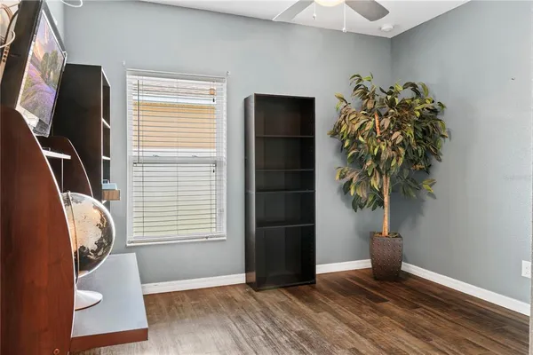 a view of a livingroom with a potted plant and wooden floor