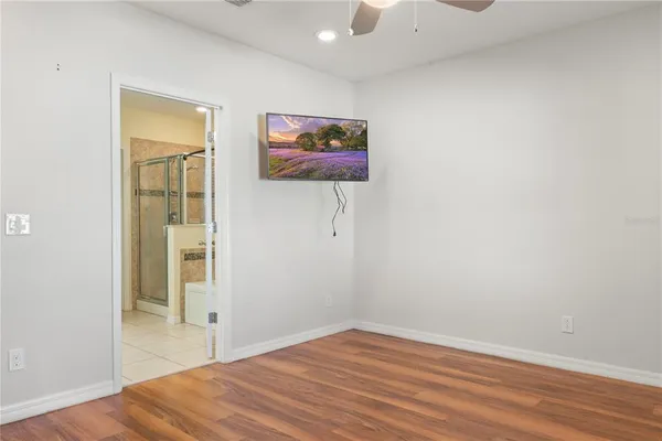 a view of a hallway with wooden floor and closet area