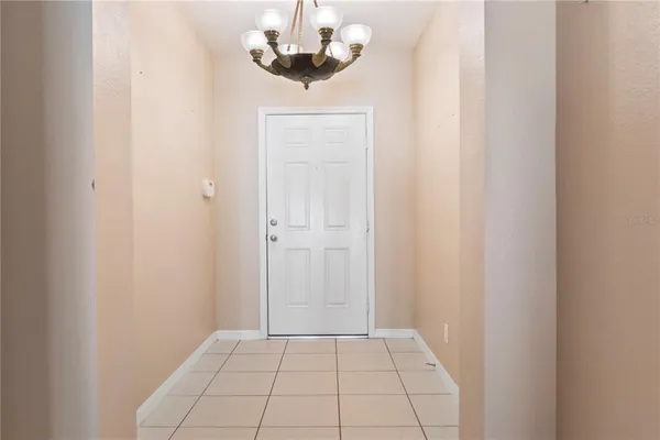 a view of an empty room and chandelier fan