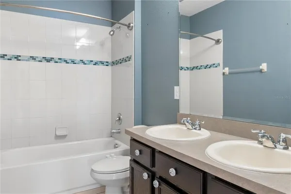 a bathroom with a granite countertop sink a toilet and shower