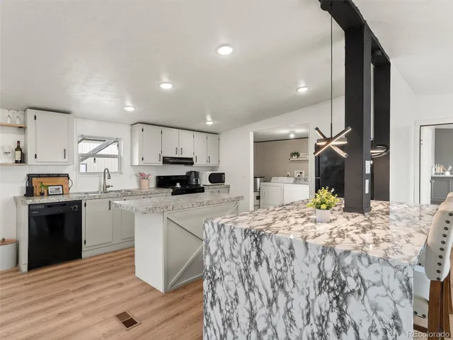 a kitchen with stainless steel appliances kitchen island granite countertop a stove and a refrigerator