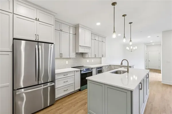 a kitchen with kitchen island white cabinets and stainless steel appliances