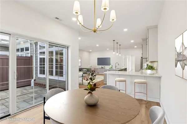 a kitchen with white cabinets and dining table
