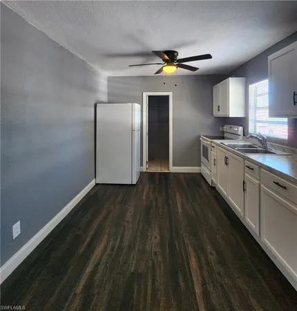 a kitchen with a refrigerator and white cabinets