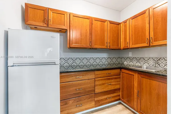 a kitchen with granite countertop cabinets and refrigerator
