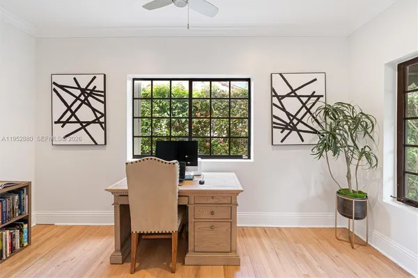 a dining room with furniture potted plants and wooden floor