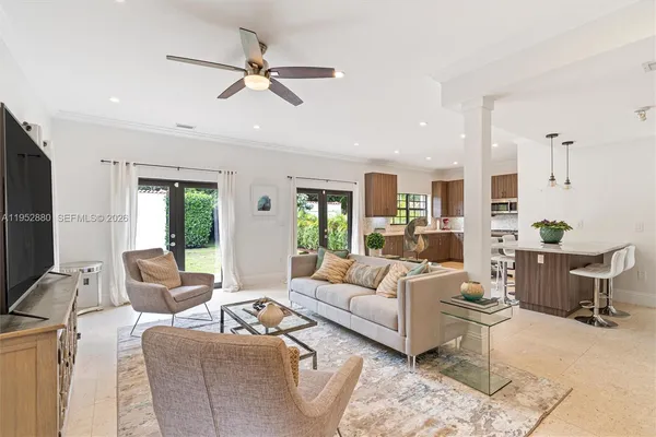 a living room with furniture kitchen view and a window