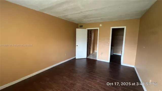an empty room with wooden floor and closet