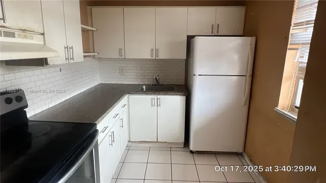 a kitchen with a refrigerator and a sink