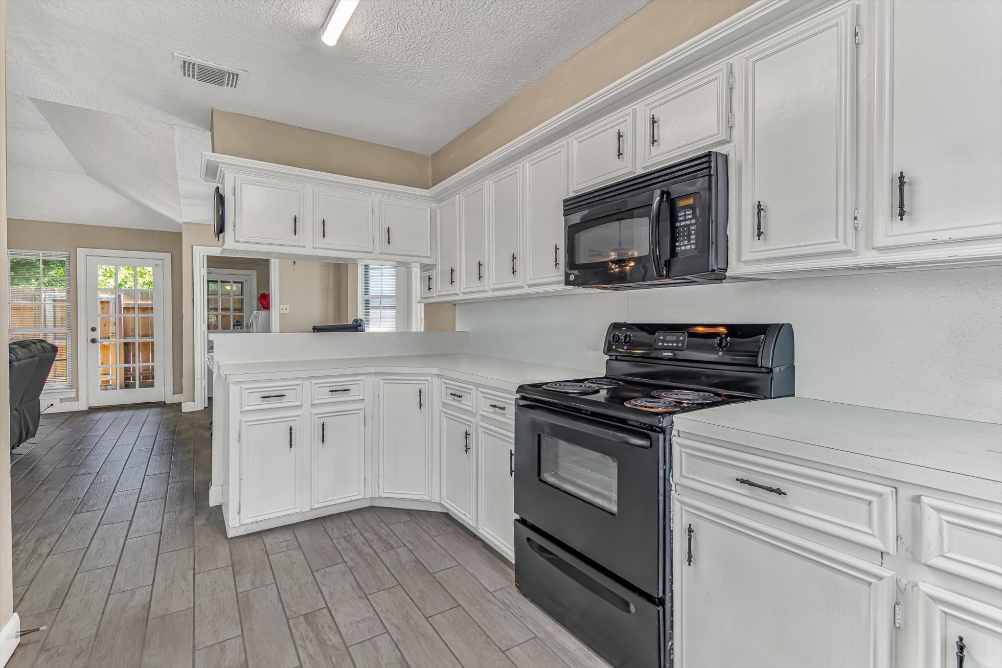 26822 Prairie Lane Katy, TX 77494 - Photo 17 of 30 a kitchen with stainless steel appliances granite countertop white cabinets a sink a stove a microwave and wooden floors