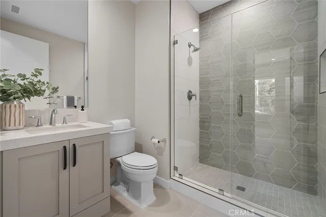 a bathroom with a shower a sink a toilet and mirror
