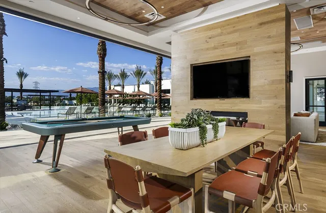 a outdoor dining space with furniture and a flat screen tv