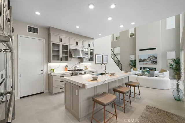 a kitchen with stainless steel appliances kitchen island granite countertop a stove and a refrigerator