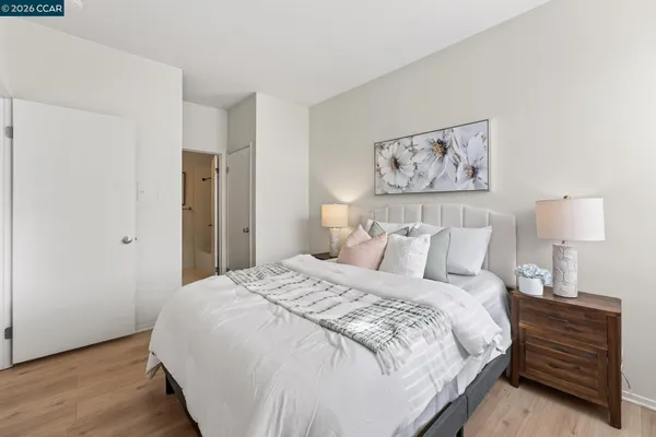 a bedroom with a bed and a lamp on dresser