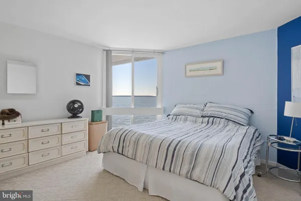 a bedroom with a bed and a lamp on dresser