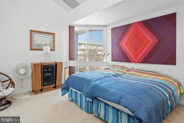 a bedroom with a bed and a flat tv screen on dresser