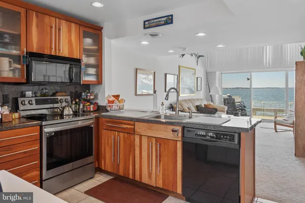 a kitchen with stainless steel appliances granite countertop a stove sink and cabinets