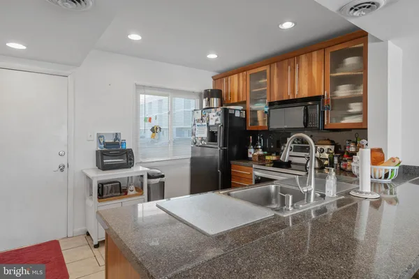 a kitchen with stainless steel appliances granite countertop a stove refrigerator and a sink