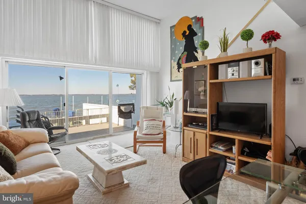 a living room with furniture a flat screen tv and kitchen view