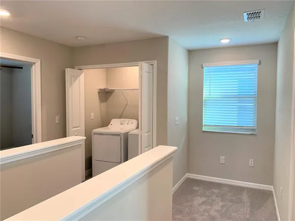 an empty room with a window and a fan