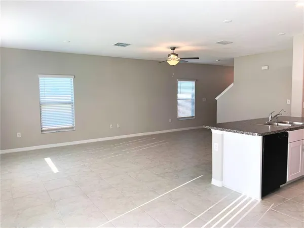 an empty room with a kitchen and windows
