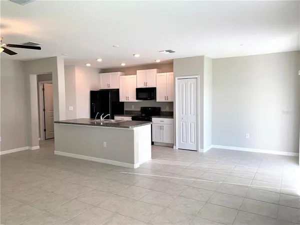 a view of kitchen with kitchen island stainless steel appliances a refrigerator a stove top oven and a sink