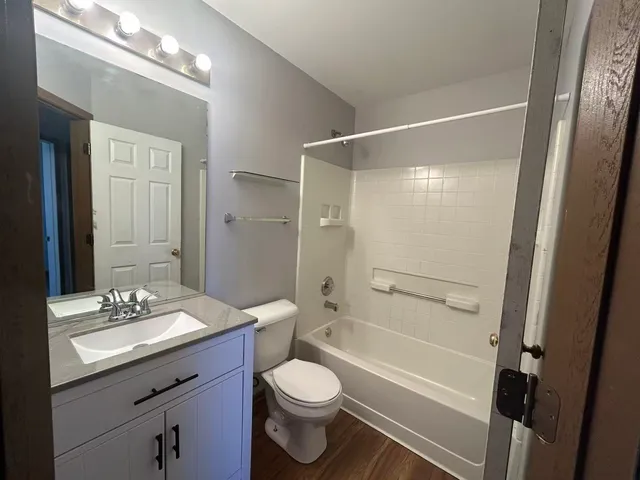 a bathroom with a double vanity sink toilet mirror and shower