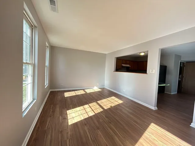 a view of empty room with wooden floor
