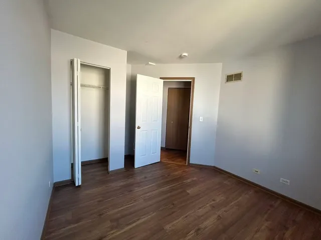 an empty room with wooden floor and closet